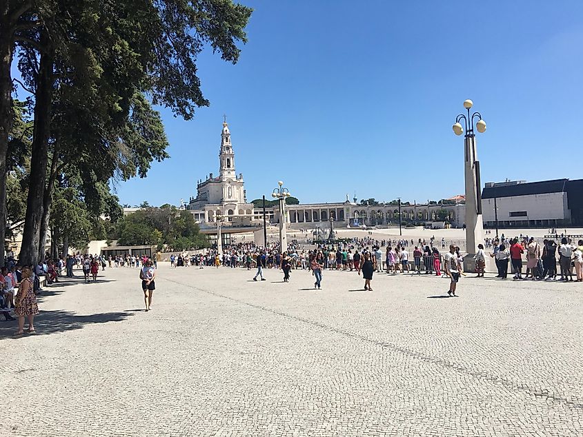 A line up out side of the Santuário de Fátima on a sunny day.