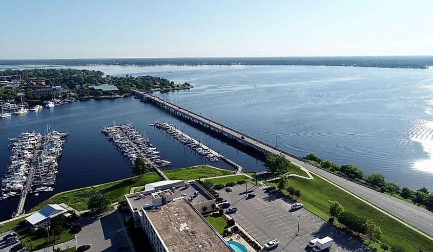 Several boats docked near a bridge in beautiful New Bern