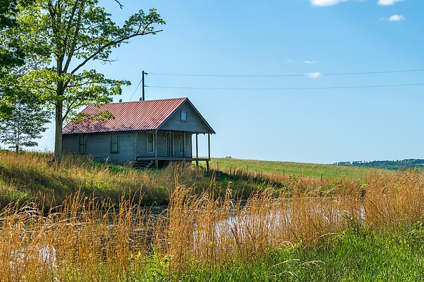 Rural old house barn reflected in pond water in northwest Arkansas, Ozark mountains, beautiful scenic view