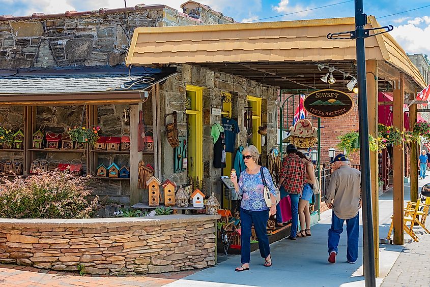 Туристы проходят мимо магазина Sunset Tee's & Hattery на Главной улице в Блоуинг-Роке, Северная Каролина, США