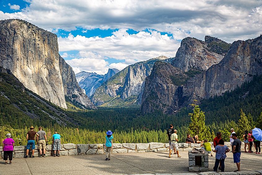 Tourists taking photos of El Capitan, Half Dome and Bridalveil Fall from Tunnel view in Yosemite National Park, California