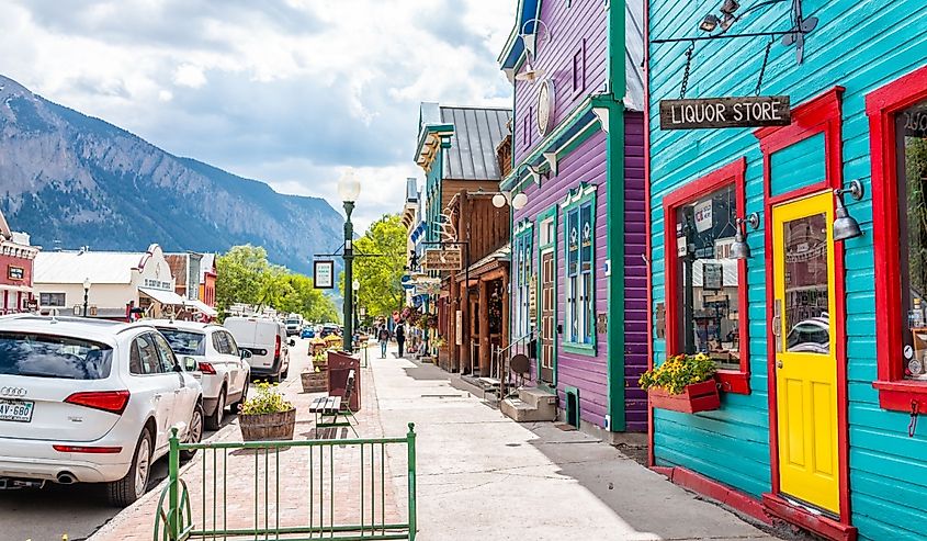 Colorado colorful vivid village houses stores shopping downtown in summer with vintage mountain architecture and cars on street in Crested Butte, Colorado