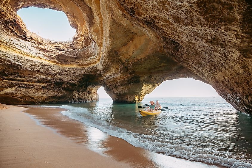 Couple on a kayak exploring the Benagil sea cave in Algarve. Credit: iacomino FRiMAGES / Shutterstock