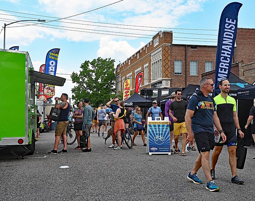 EMPORIA, KANSAS USA - JUNE 2, 2023 Some of the 4000 bike racers that are competing in tomorrow's Unbound Gravel dirt bike races stroll along the vendors booths set up along the streets of downtown.