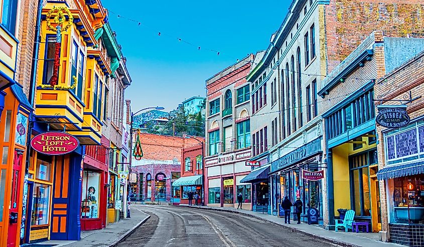 Buildings lining Main Street on a clear day at the edge of Bisbee, Arizona.