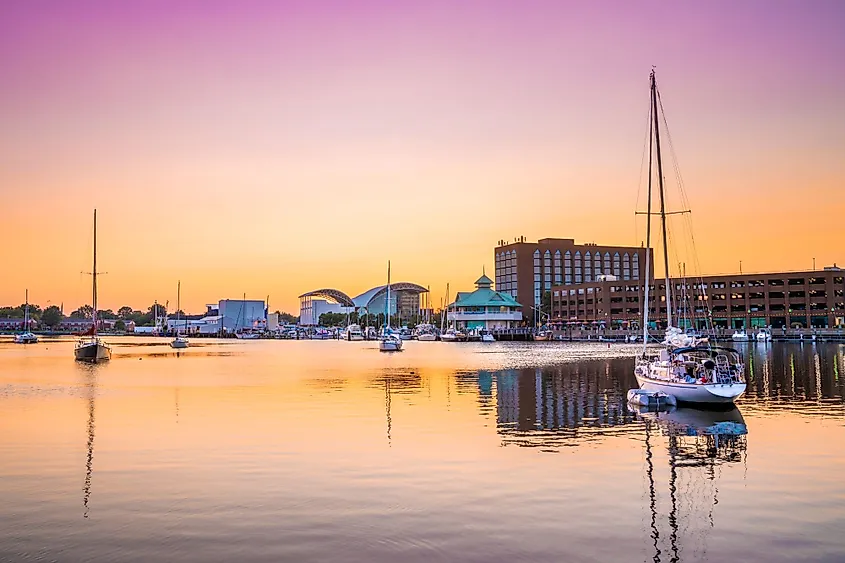 View of Hampton, Virginia downtown waterfront district seen at sunset under colorful sky. 