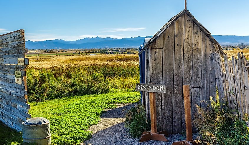 An old rustic outhouse sits in a field in Belgrade, Montana