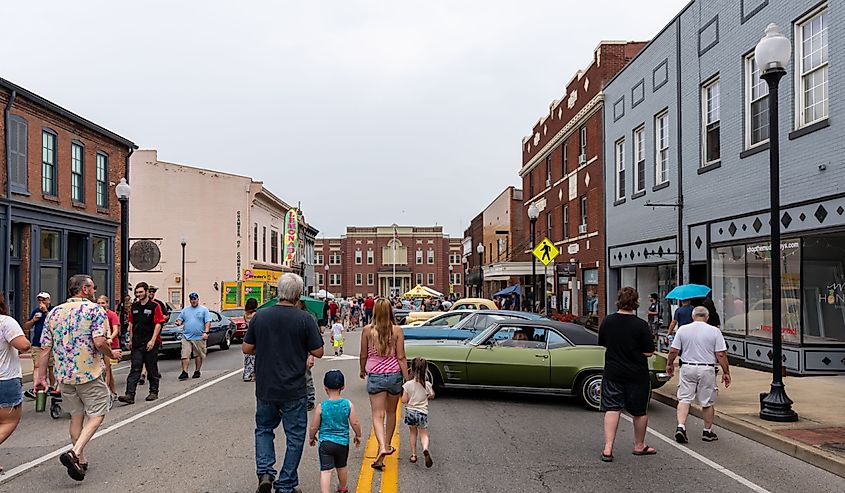 Spectators walk in the streets with cars on display during the Cruisin' The Heartland 2021 car show in downtown Elizabethtown, KY.