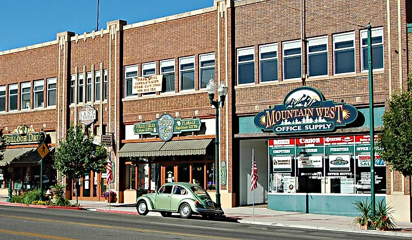 Street view of a vintage town with a historic brick building, colorful shop signs, and a classic green beetle car parked along the sidewalk, evoking nostalgia.