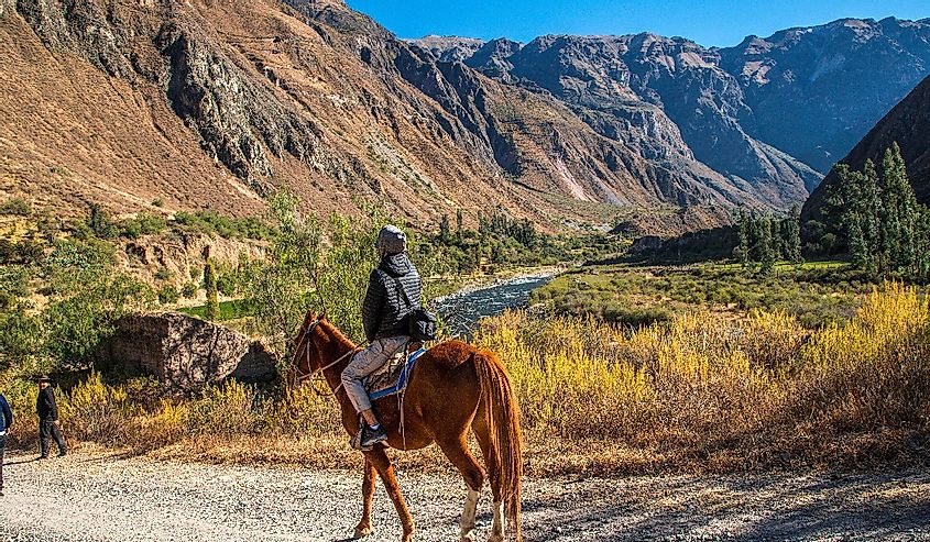 Woman on horseback through Cotahuasi Canyon, Peru. 
