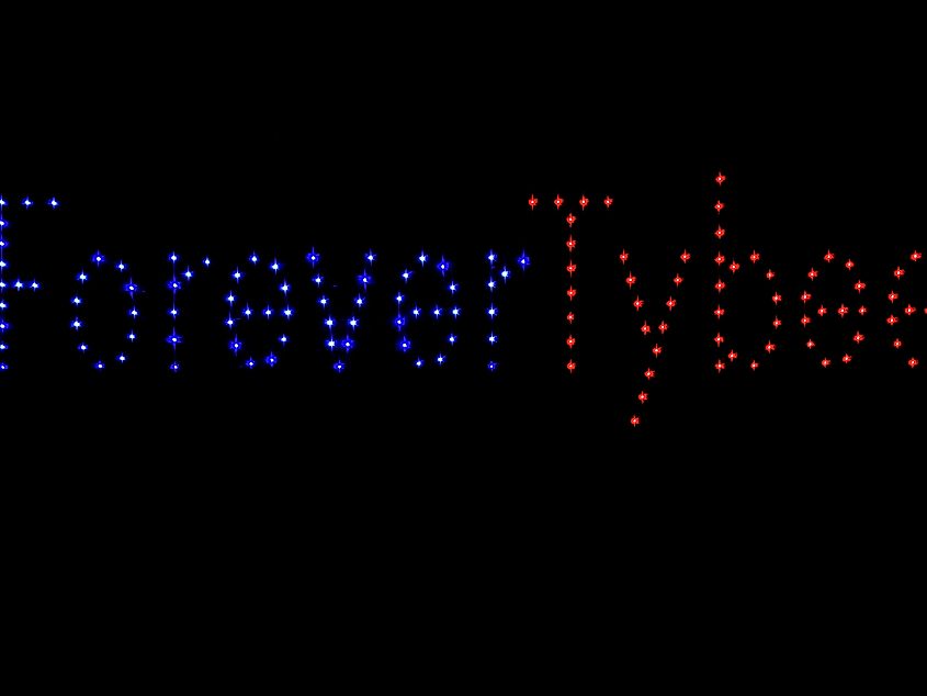Drone show making spelling out the words Forever Tybee at night in Tybee Island, Georgia taken from the pier.
