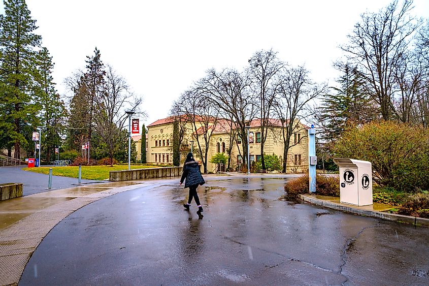 Student walking across campus of Southern Oregon University in Ashland, Oregon during a snowy and cold winter day