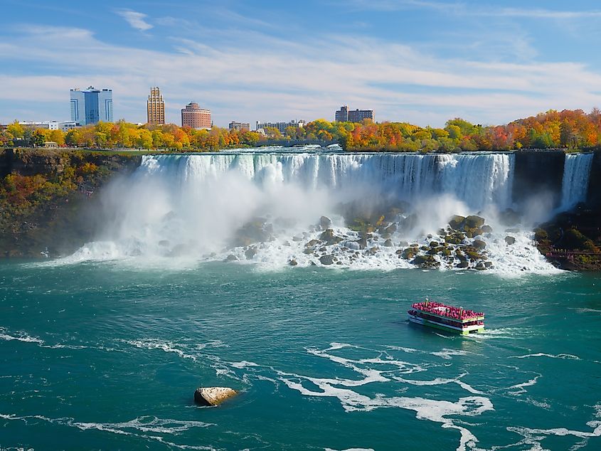 Niagara Falls. A pleasure boat with people near the huge famous waterfall. View from the Canadian side.