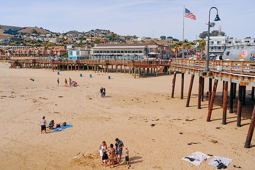 Wooden boardwalk along the shore, wide sandy beach, and plaza in downtown of Pismo Beach, via HannaTor / Shutterstock.com