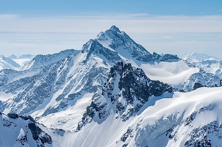 Panoramic view of the snow-covered Alps and blue sky around Mount Titlis in Switzerland.