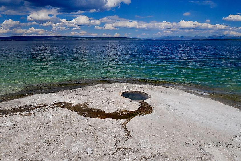 Big Cone Geyser in West Thumb Geyser Basin, with the Yellowstone Lake in the background.