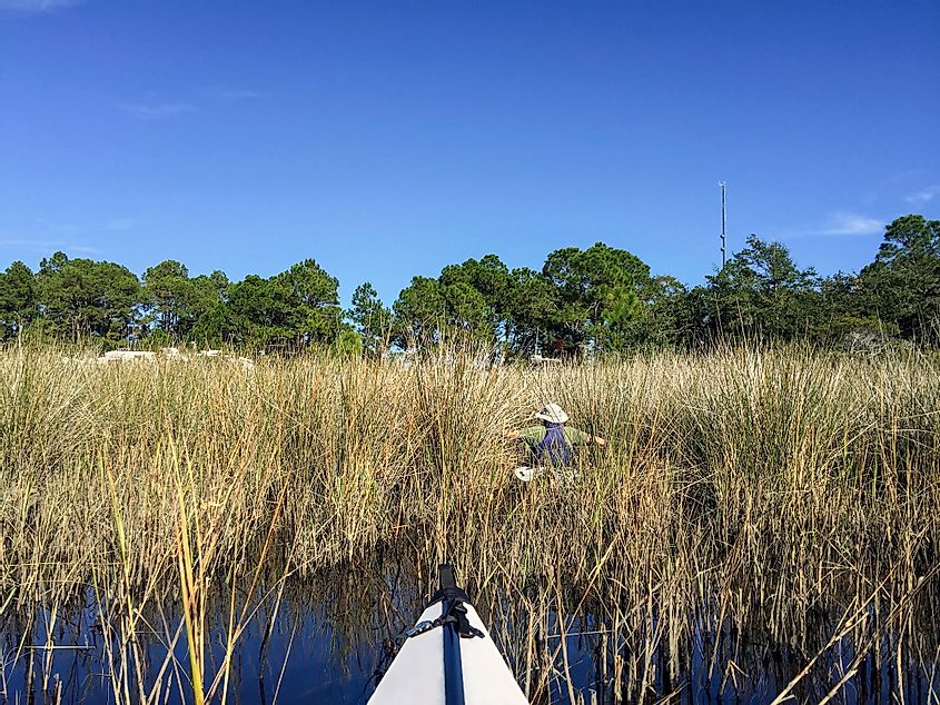 A couple paddles in kayaks along the salt marsh near Carabelle on the Florida Panhandle.