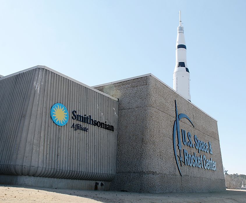 Exterior of the U.S. Space and Rocket Center with a Saturn V rocket rising behind it.