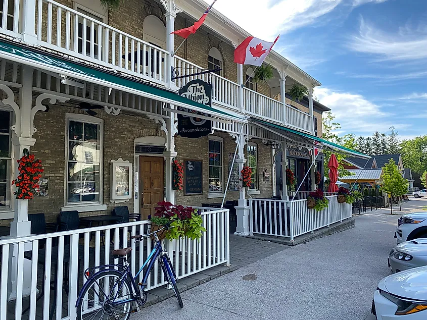 A bicycle leans against the white fence of a historic hotel and pub called The Albion.