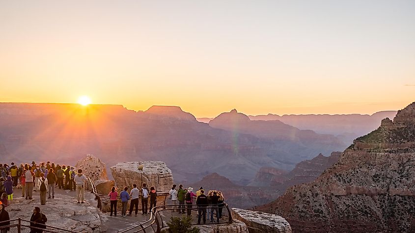 Visitors watching the sunrise over the Grand Canyon from Mather Point