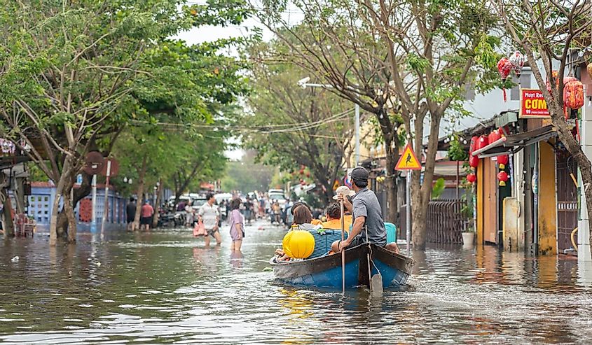 Hoi An - Vietnam, October 2022; A man is rowing boat to taking tourist group out from Hoi An ancient city during water flooding situation.