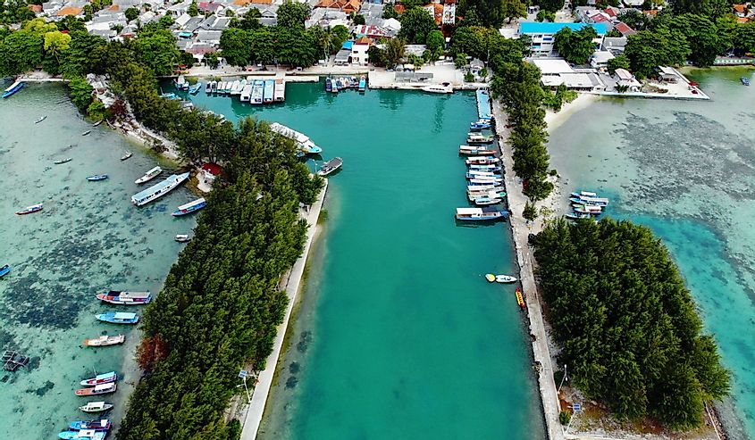 Aerial photo of beautiful morning scenery around the port of Pari Island with clear and blue sea water and there are several boats anchored, located in the Thousand Islands, Jakarta.