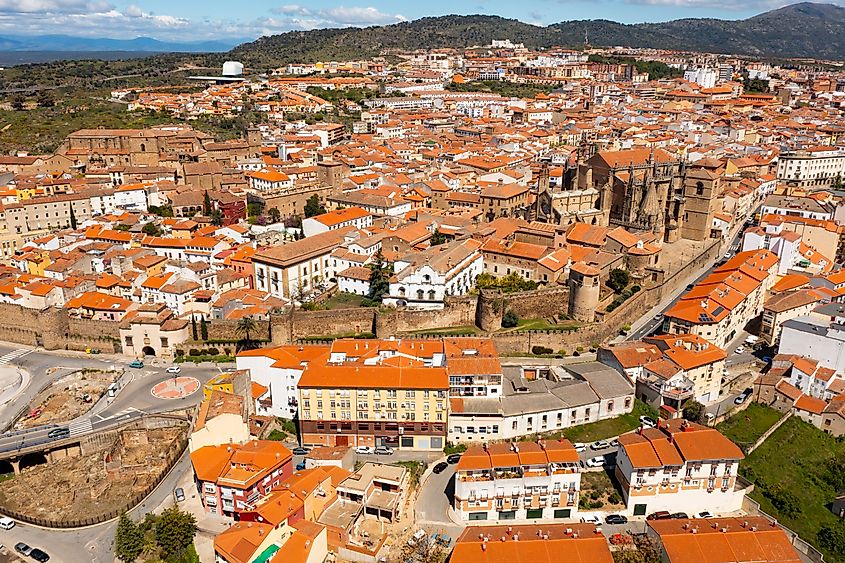 Bird's eye view of residential buildings with tiled roofs and cathedral in Plasencia, Extremadura, Spain.