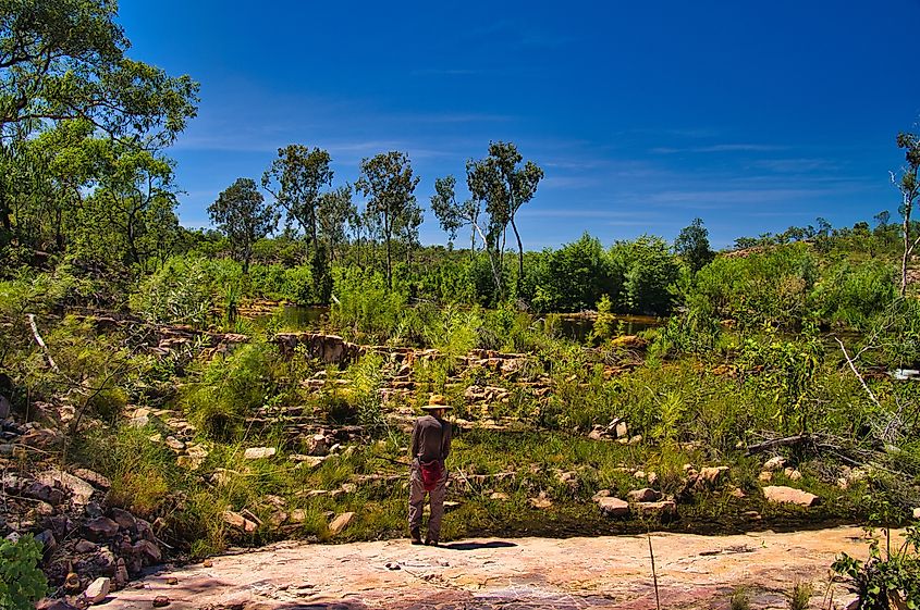 Editorial Photo Credit: Hans Wismeijer via Shutterstock. Woman hiker looking out over the rocky and green landscape along the Sweetwater Pool Walk, Edith Falls (Leliyn), Nitmiluk National Park, Katherine, Northern Territory, Australia