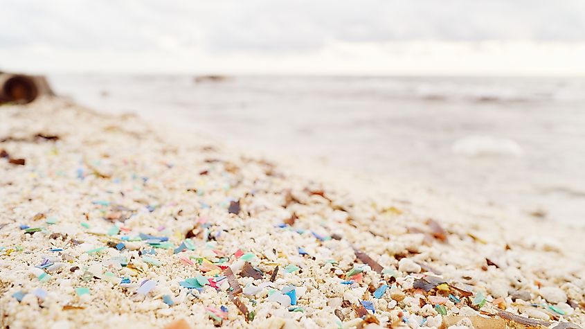 micro plastic particle pollution on beach, microplastic pieces in ocean water