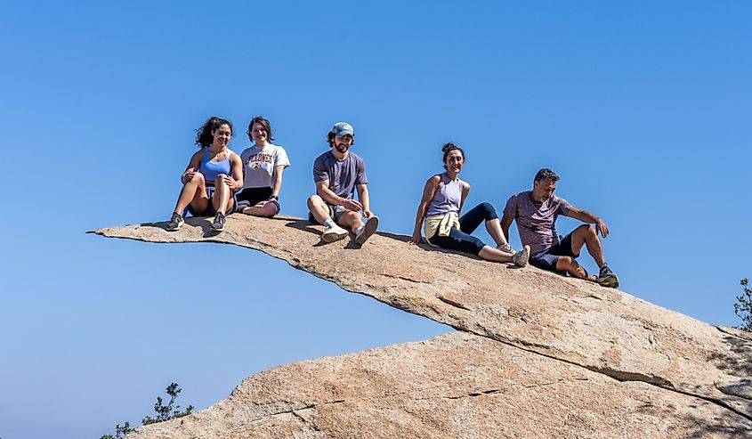 A group of five friends sit in a line on Potato Chip Rock, Ramona, California.