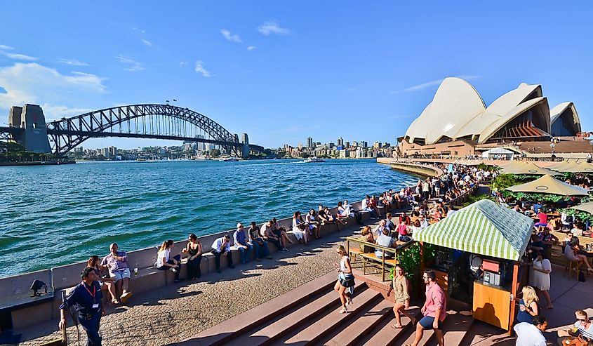 People relaxing and dining along the Circular Quay on a sunny afternoon in Sydney, Australia.