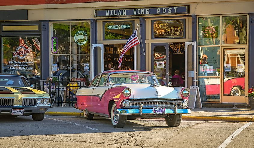 A beautiful pink Ford is parked in front of local shops on a summer cruise night, Milan, Ohio