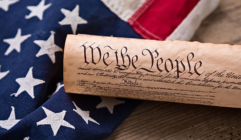 United States Constitution, rolled in a scroll on a vintage American flag and rustic wooden board