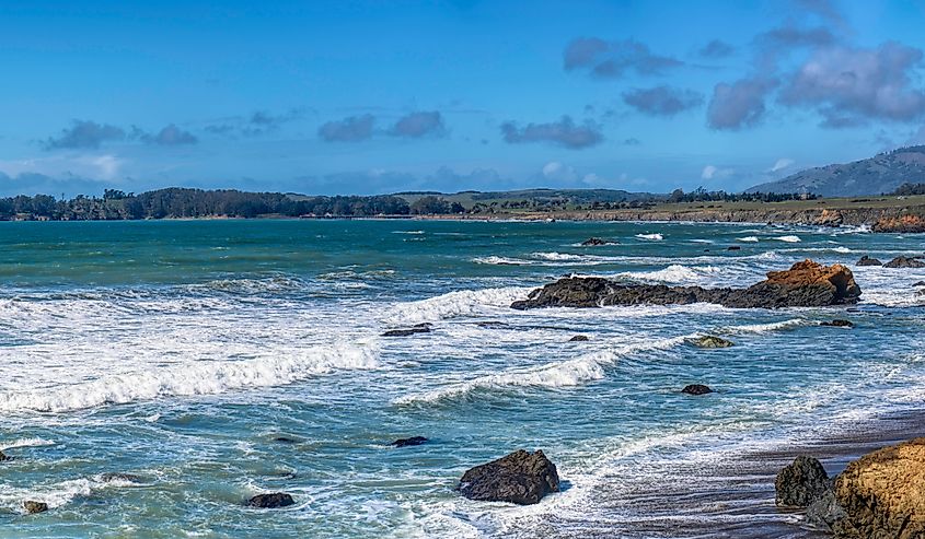 Sweeping panorama of cliffs, ocean and the San Simeon Point jutting out towards the Pacific Ocean.