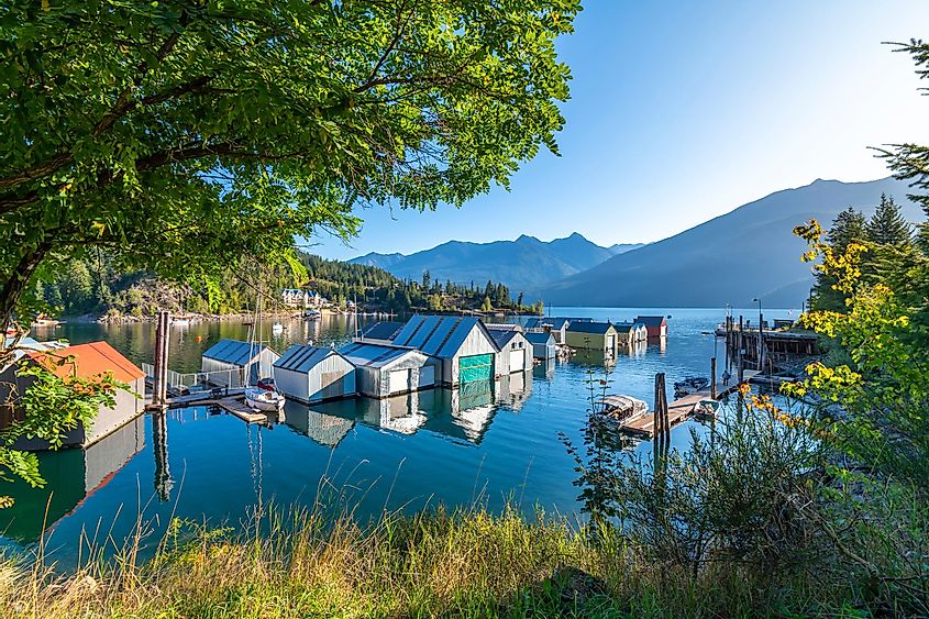 Раннее утреннее солнце освещает верфь, пристань для яхт и причал на озере Кутеней в заливе Касло, в сельской деревушке Касло, Британская Колумбия, Канада.