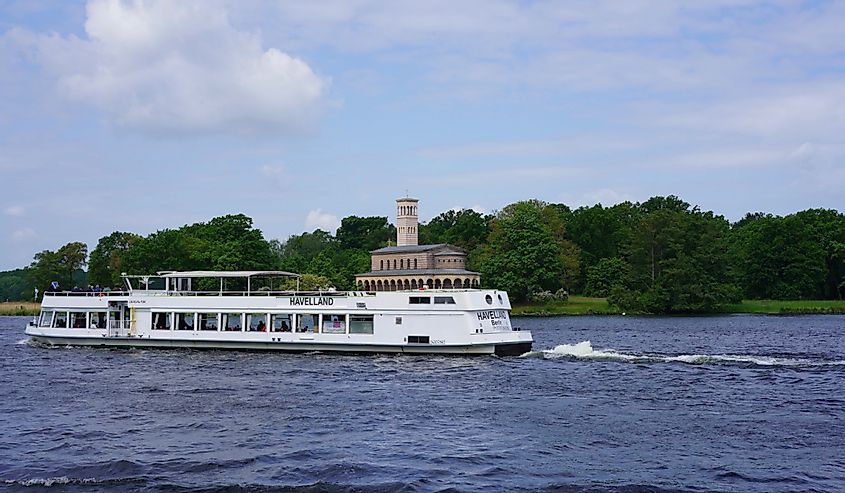 Sightseeing boat on river Havel passing famous Sacrow Curch of the Redeemer at Berlin Wall Trail.