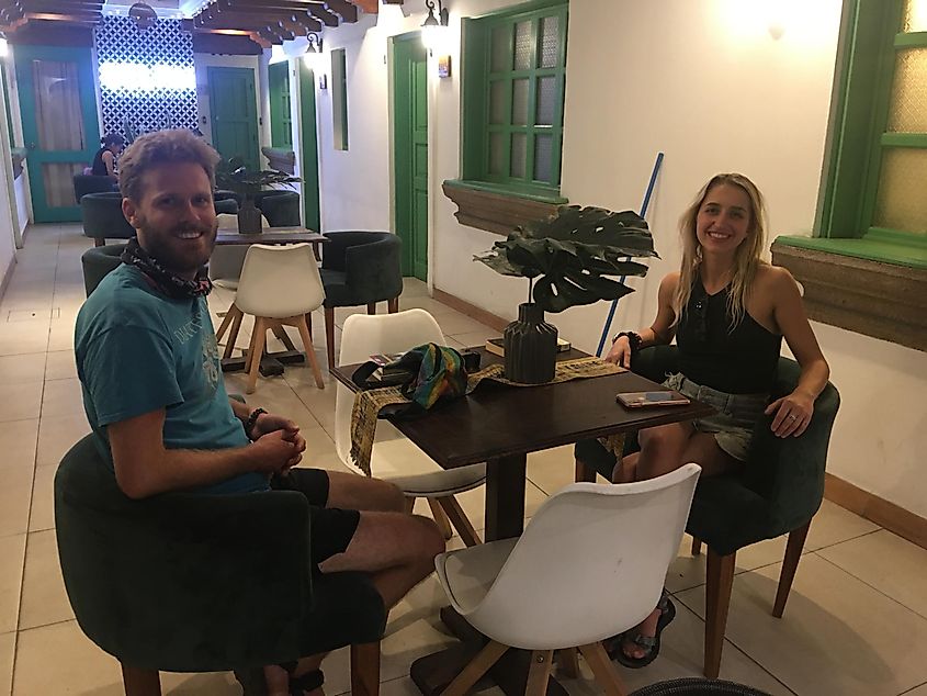 A happy couple sits at a table inside a boutique hotel.