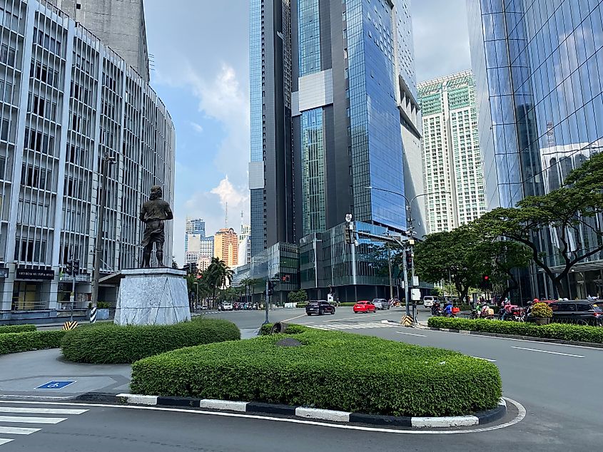 A noble statue stands in a groomed portion of a big-city intersection in Makati, Metro Manila.