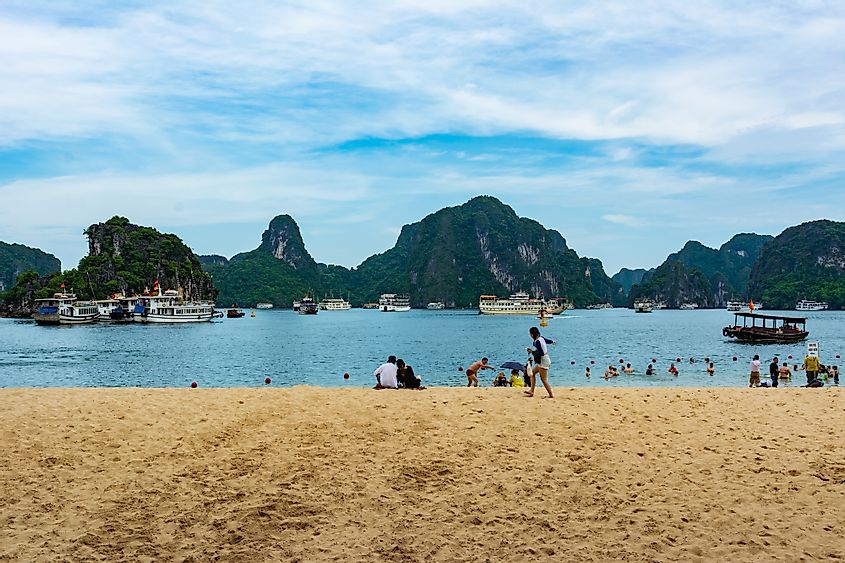 A sandy beach with a lot of tourists in Titov Island, Ha Long Bay, Vietnam.