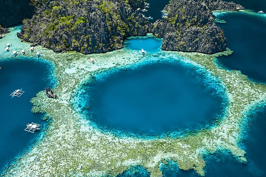 A turquoise lagoon ringed by limestone cliffs at Coron, Palawan, Philippines.