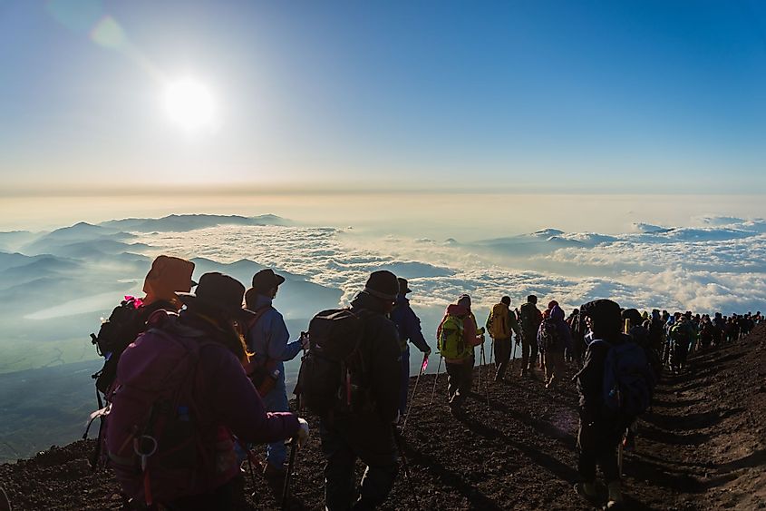 Hikers gather during sunrise on the summit of Mount Fuji