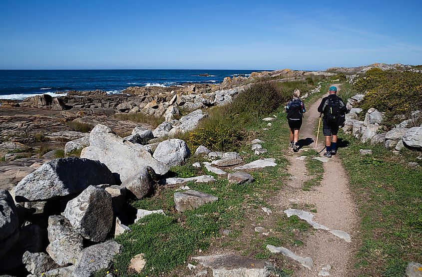 Two pilgrims walk the Portuguese Camino de Santiago along the coast in A Guarda