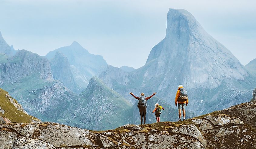 Family travel adventure in Norway mountains, parents and child on active outdoor vacation.
