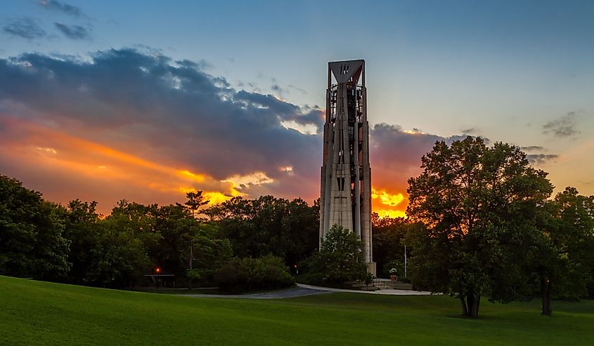 Sunbeams bursting through clouds at sunset behind the Carillon Bell Tower in Naperville, Illlinois