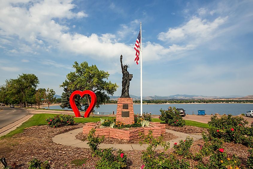  Red Heart, copy of the Statue of Liberty and American flag in the city park on the Loveland lake shores