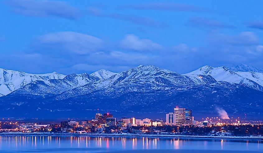 Anchorage Alaska skyline in winter at dusk with the Chugach mountains behind.