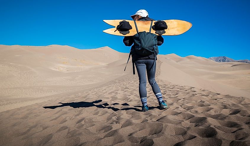 A sandboarder surveys the scene at Great Sand Dunes National Park.