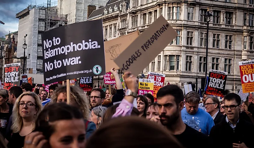 A group of young protestors holding signs about Islamophobia and war