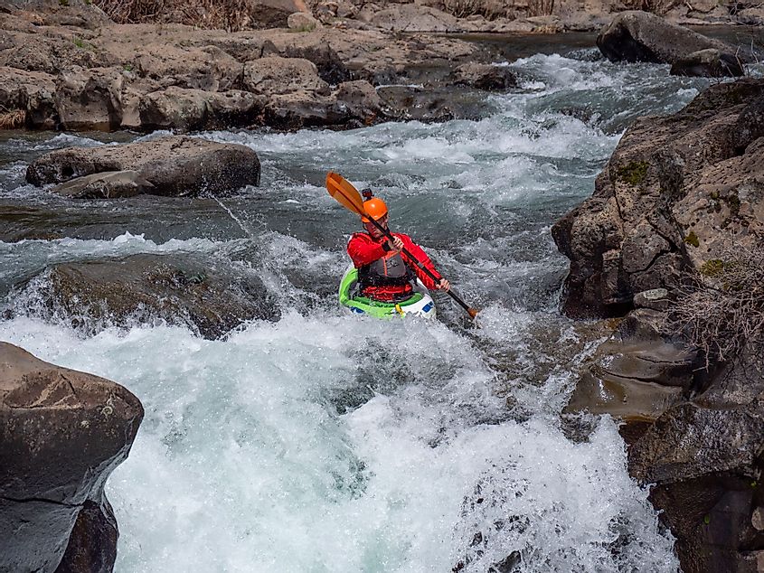Extreme athlete whitewater kayaking over a waterfall on the McCloud River in northern California
