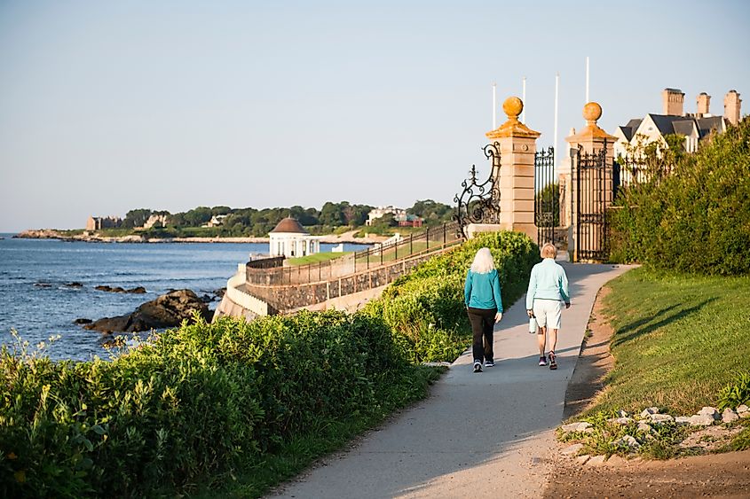 A couple walking on the Newport Cliff Walk in Newport, Rhode Island. Image credit: Cavan-Images / Shutterstock.com.